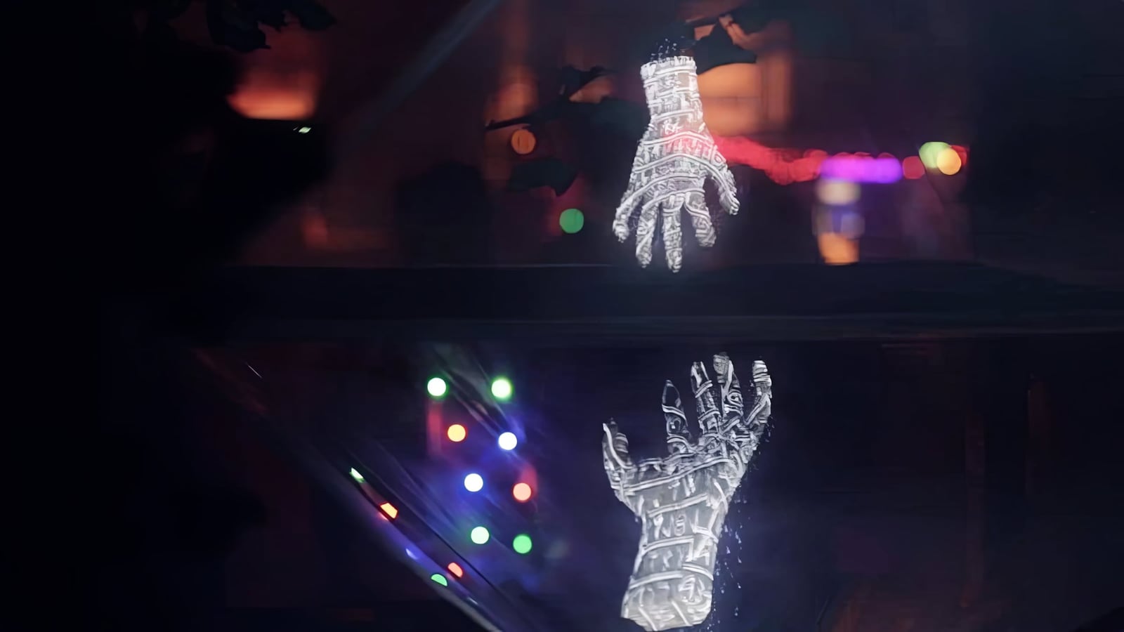 Two projected hands reach towards one another across a dark reflective surface.