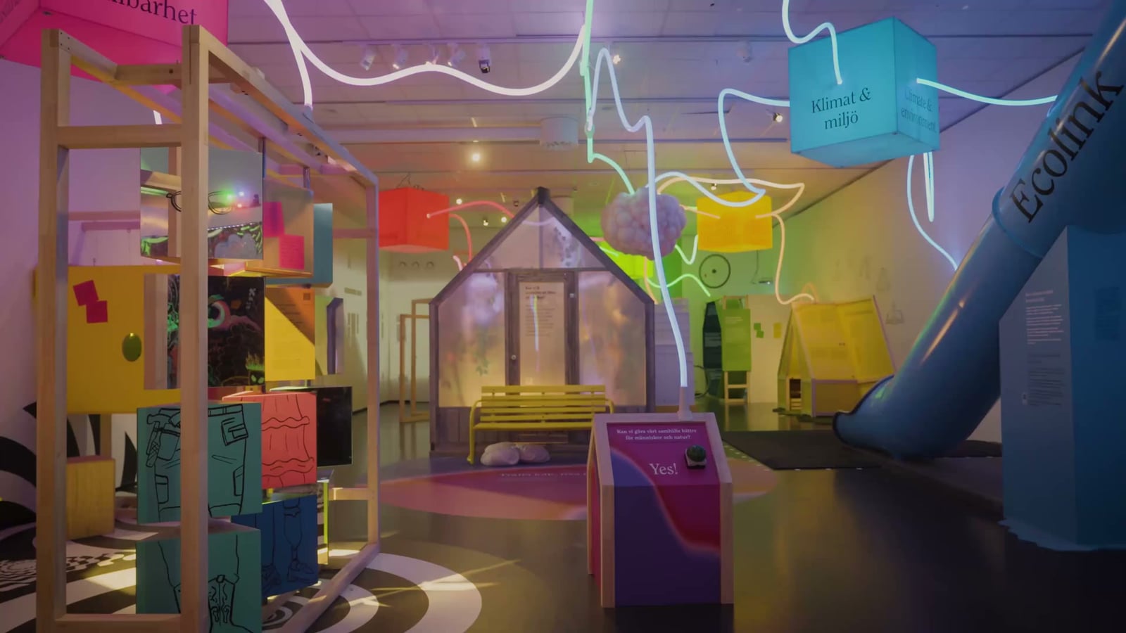 Light trails wind through Society Expo's empty exhibition rooms, with a close view of the suspended cloud and green and amber lighting.