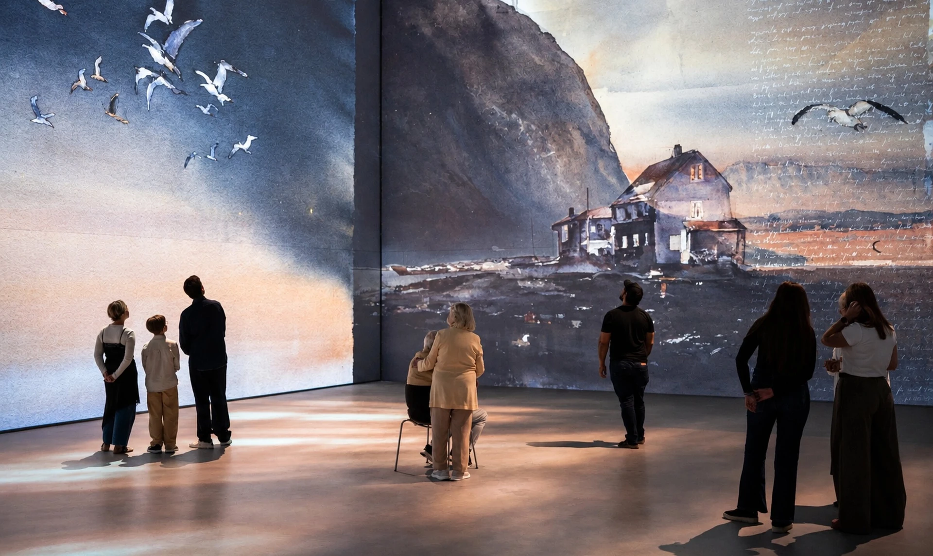 An installation view of Det Mörka Ljuset, with visitors surrounded by Lars Lerin's watercolours of birds, mountains and a house by the sea.